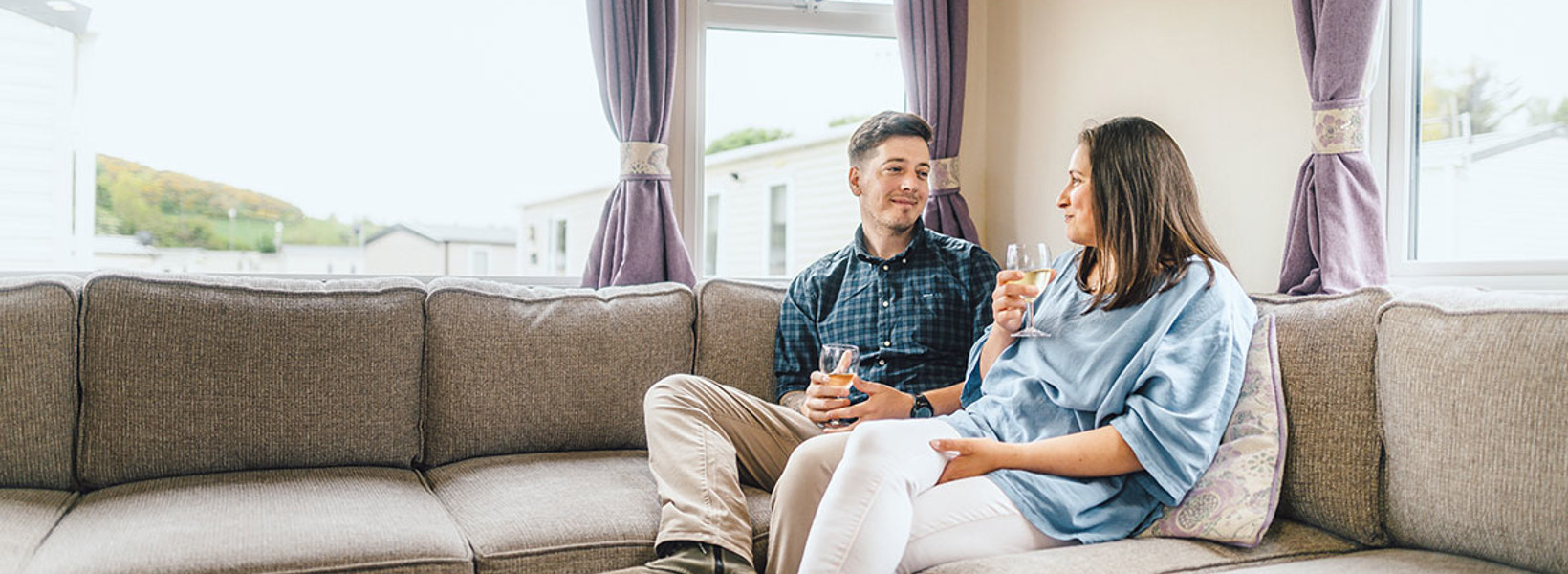 Couple relaxing in a caravan at Scoutscroft Leisure Park