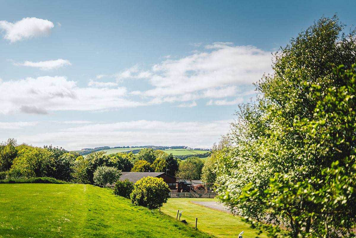 Green hills, trees and the clubhouse at Thurston Manor