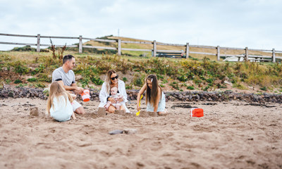 Family building sandcastles on the beach at Pease Bay 