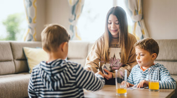Children playing a card game in caravan accommodation at Coldingham Bay