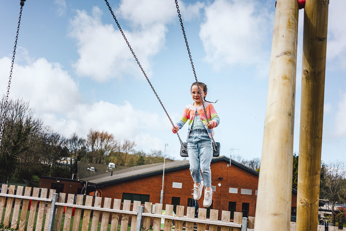 Child on swing at play area at Thurston Manor