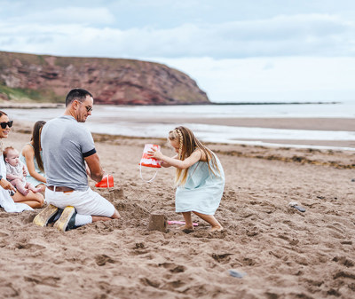 Children and family playing on the beach at Pease Bay